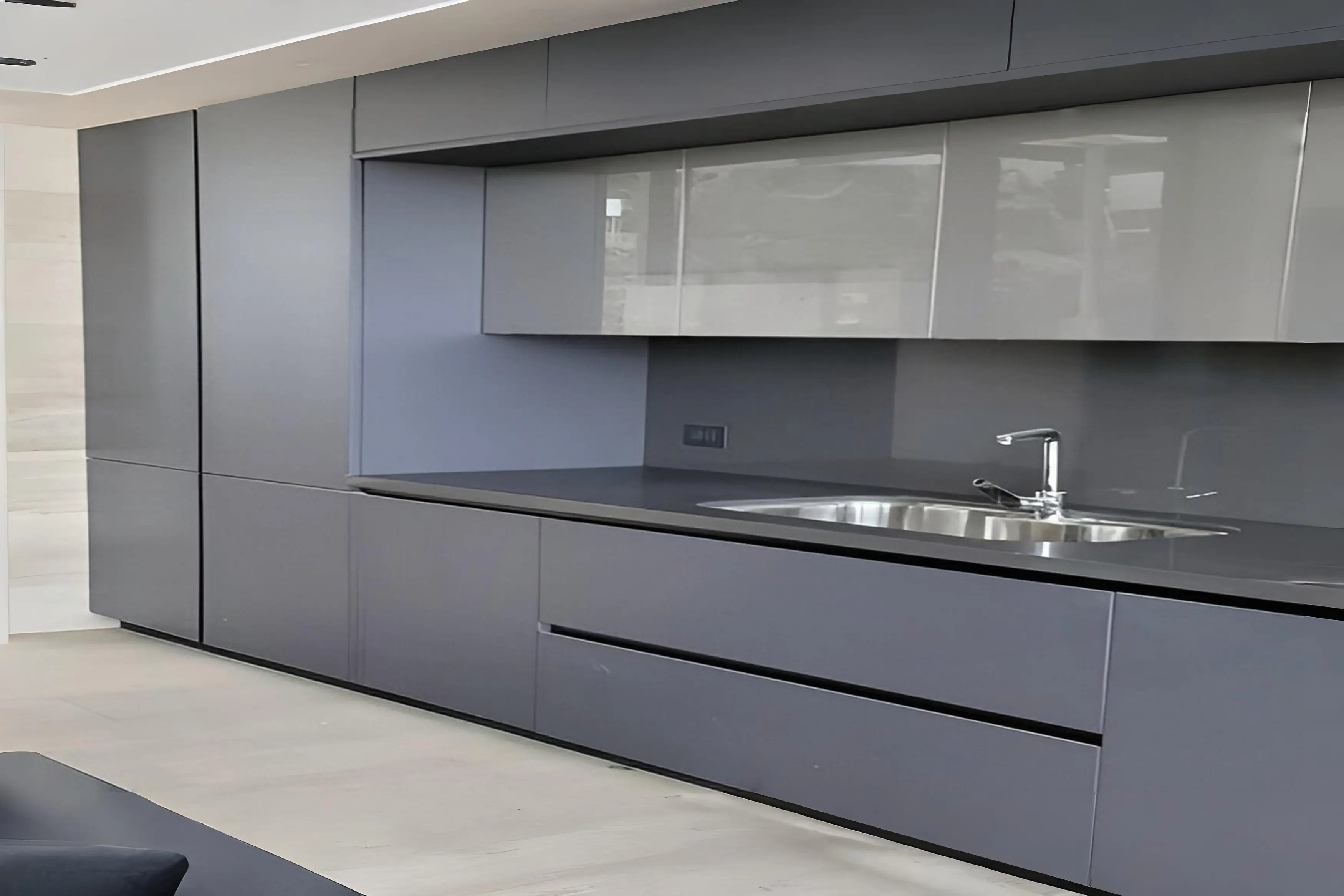 Cocina moderna en Chile con gabinetes gris oscuro, cubierta de cuarzo negro y módulos superiores con puertas de vidrio reflectante